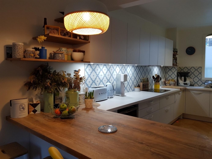 Cuisine en U avec une crédence en carrelage aux motifs bleus et un espace dinatoire en bois