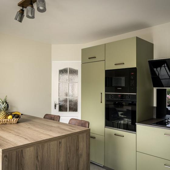 Îlot central en bois avec table intégrée et colonnes d'électroménager encastrées dans une cuisine design à Châteaubriant